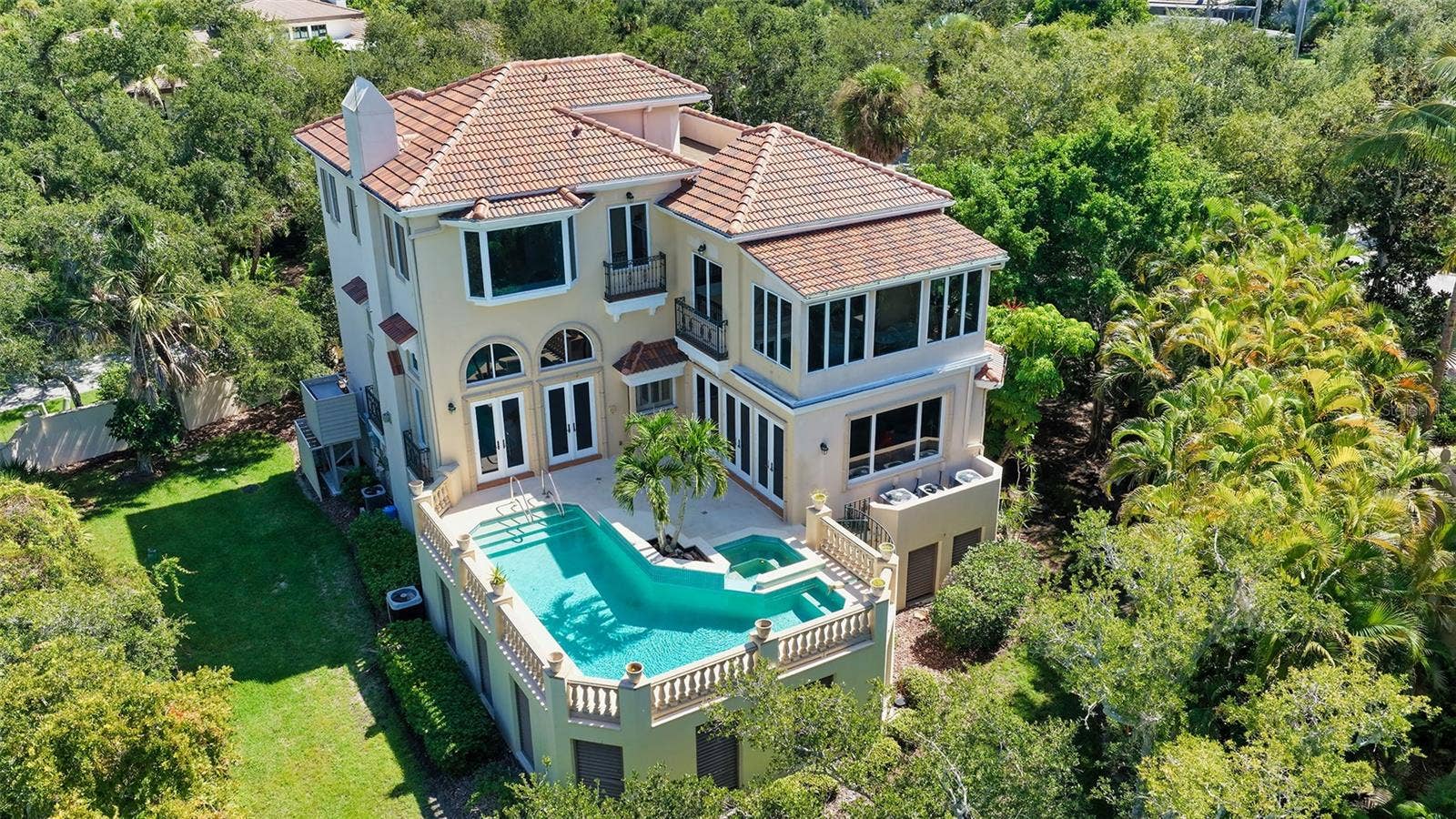 168 COASTAL HAMMOCK COURT, Osprey, FL 34229 An aerial perspective reveals the home's exceptional privacy, elevated pool terrace and lush natural surroundings.