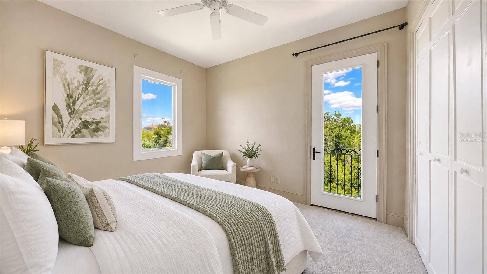 168 COASTAL HAMMOCK COURT, Osprey, FL 34229 Bedroom Three (Virtually Staged) features a balcony with surrounding greenery in this peaceful and private upper level bedroom.
