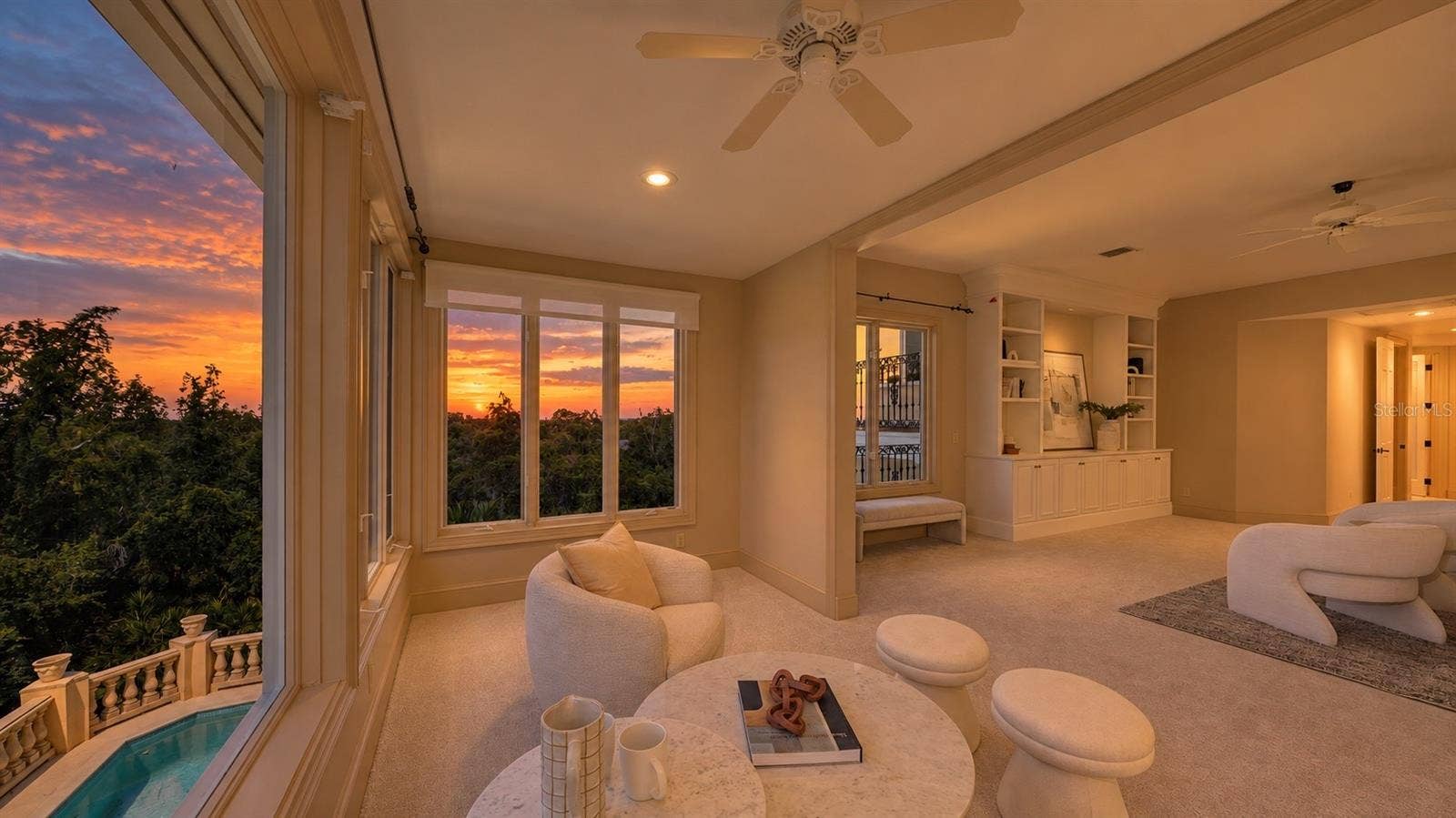 168 COASTAL HAMMOCK COURT, Osprey, FL 34229 The primary sitting area captures the warm glow of sunset over the surrounding coastal landscape.