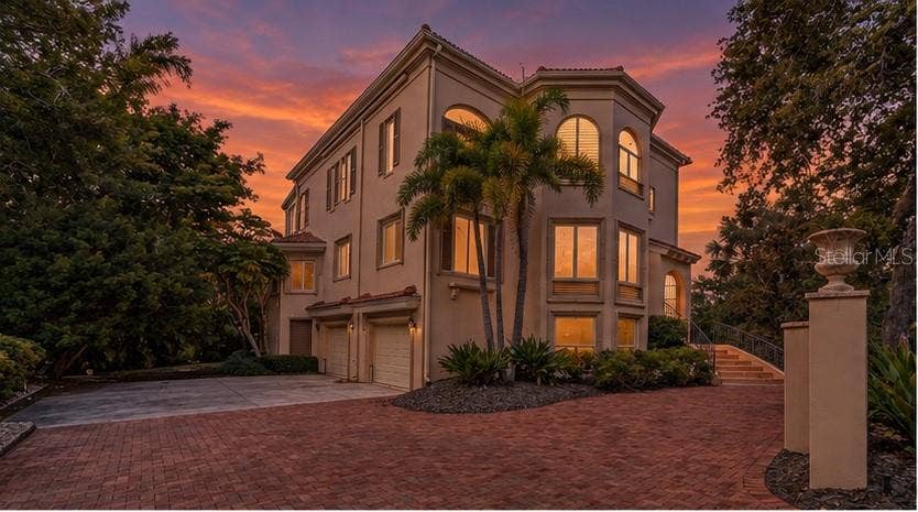 168 COASTAL HAMMOCK COURT, Osprey, FL 34229 The home's distinctive architecture takes on a dramatic presence beneath Sarasota's colorful evening skies.