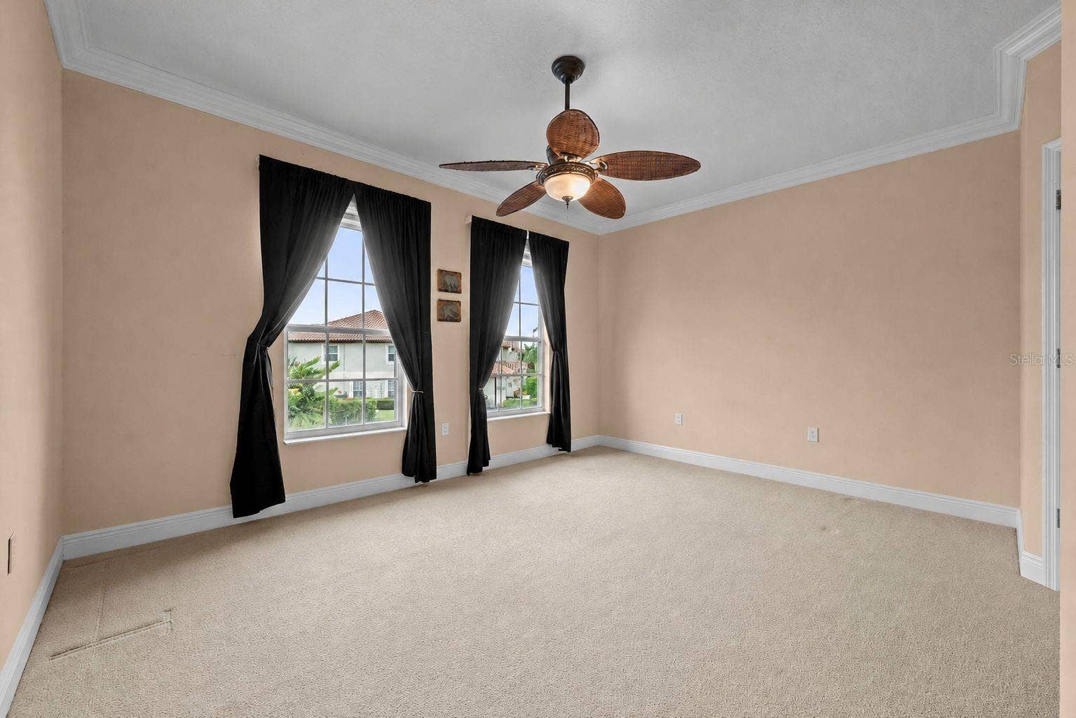 8432 MIRAMAR WAY, Lakewood Ranch, FL 34202 A spacious bedroom with soft natural light, crown molding, and room to make it your own-with walk-in closet