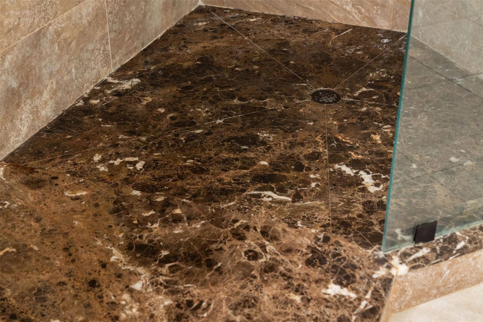 8432 MIRAMAR WAY, Lakewood Ranch, FL 34202 Richly patterned stone gives the walk-in shower a distinctive finishing touch.