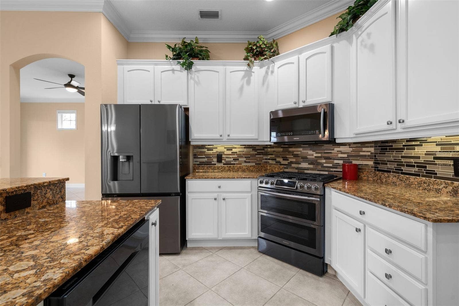 8432 MIRAMAR WAY, Lakewood Ranch, FL 34202 A gas range, decorative backsplash, and under-cabinet lighting bring style and function to meal prep.