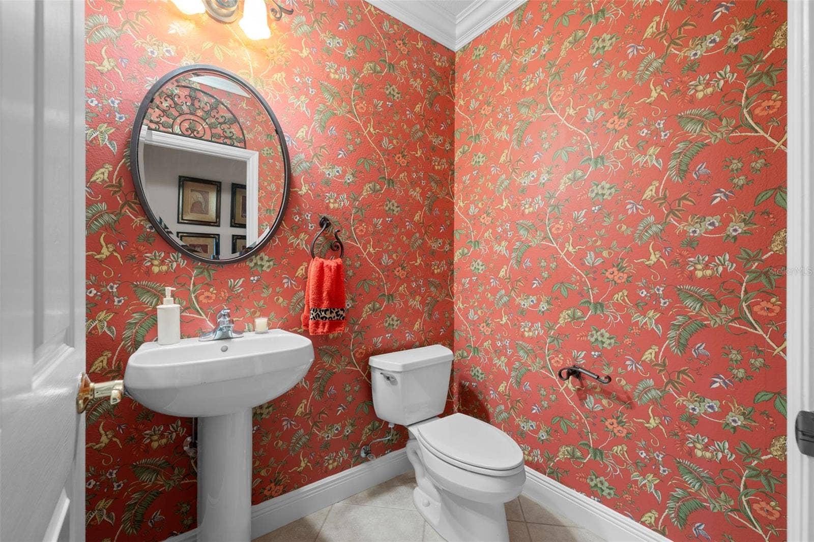 8432 MIRAMAR WAY, Lakewood Ranch, FL 34202 Cheerful patterned wallpaper and a classic pedestal sink bring personality to this bathroom.