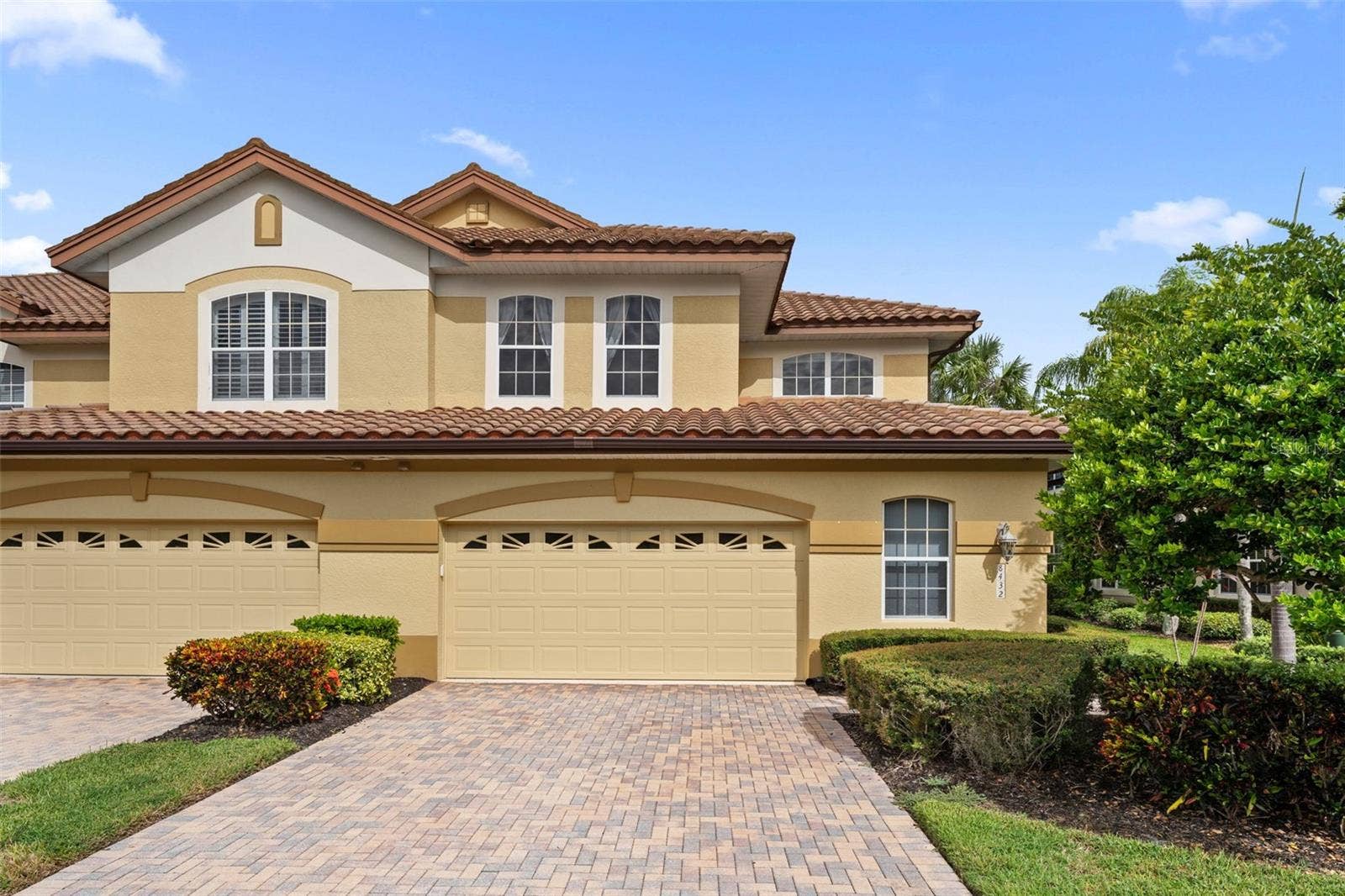 8432 MIRAMAR WAY, Lakewood Ranch, FL 34202 A paver driveway, tropical landscaping, and tile roof give this end-unit home inviting curb appeal.