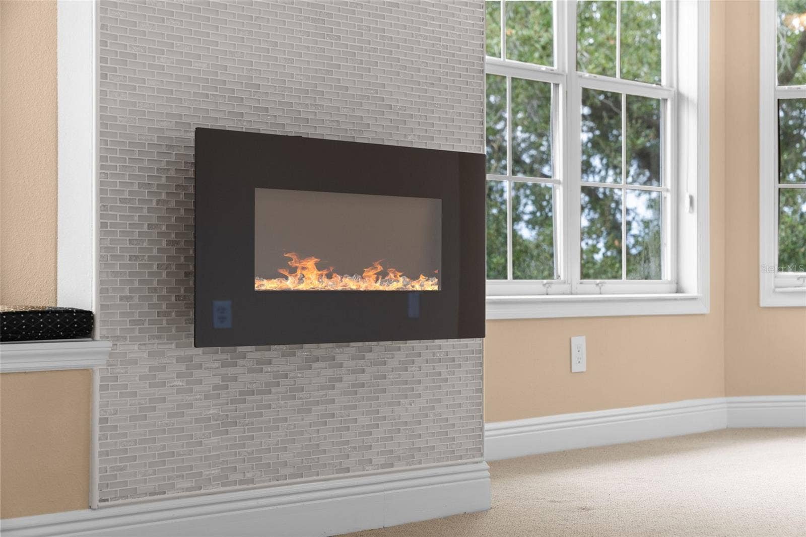 8432 MIRAMAR WAY, Lakewood Ranch, FL 34202 A fireplace with a mosaic tile surround adds a cozy touch to the primary suite.