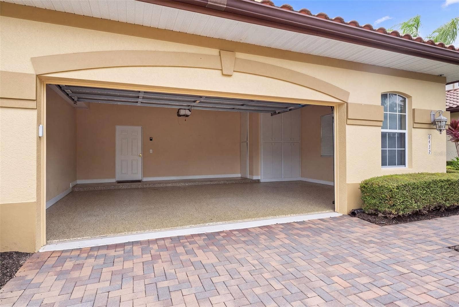 8432 MIRAMAR WAY, Lakewood Ranch, FL 34202 A spacious 28-by-22-foot garage offers room for two cars, a golf cart, and your Florida adventure gear.