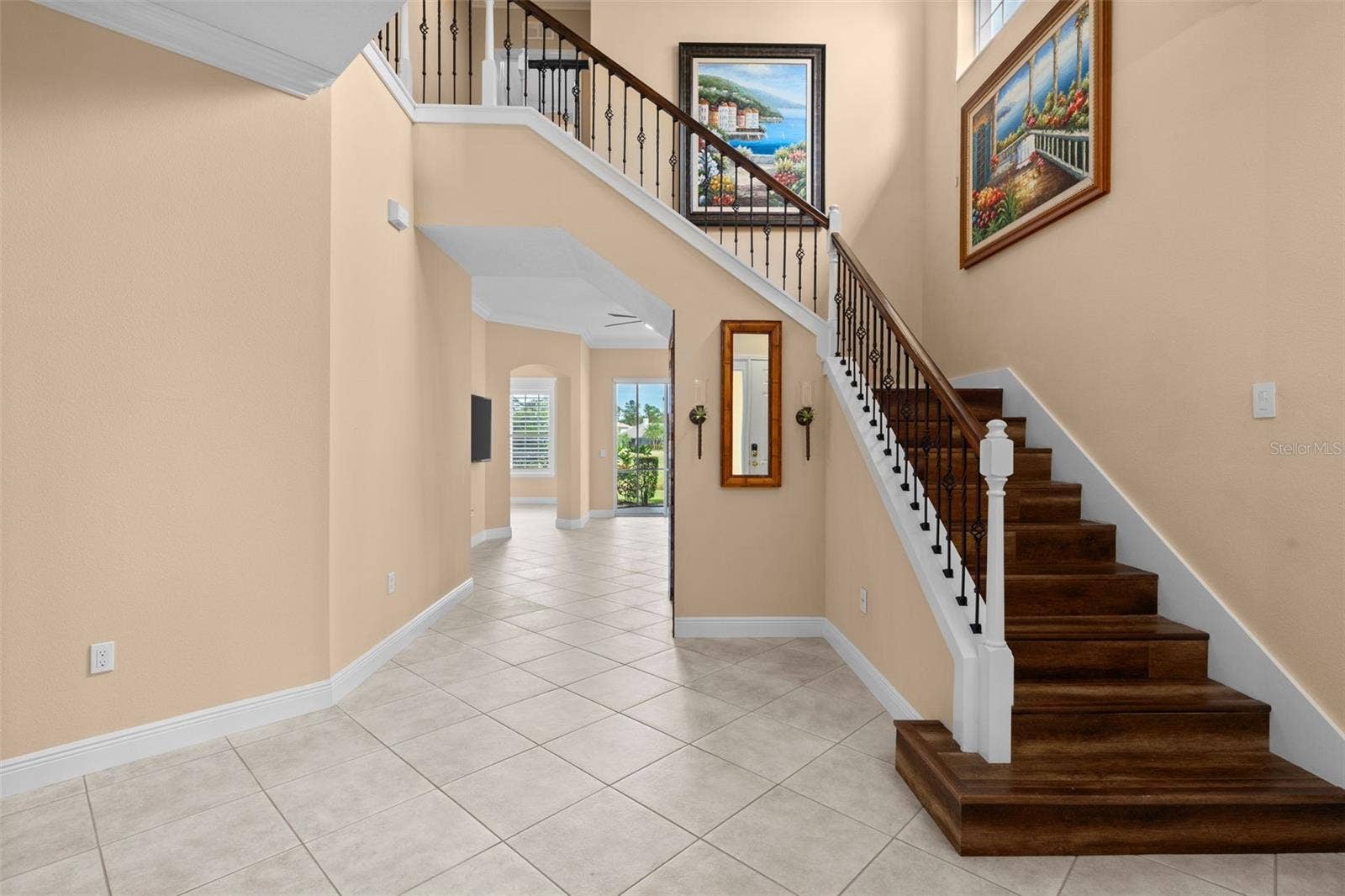 8432 MIRAMAR WAY, Lakewood Ranch, FL 34202 Soaring ceilings and a wood staircase with wrought iron accents make a memorable first impression.