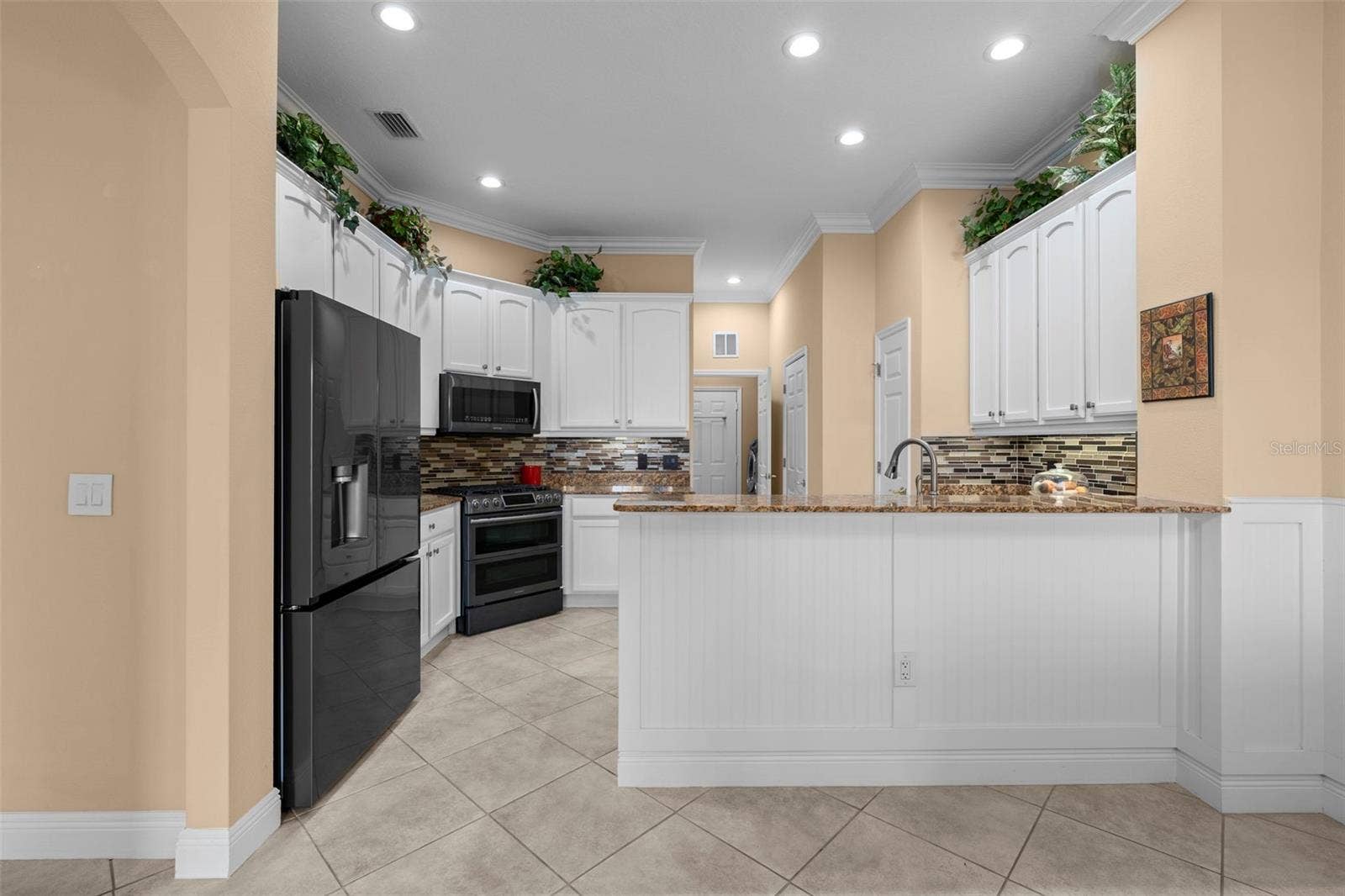8432 MIRAMAR WAY, Lakewood Ranch, FL 34202 White cabinetry, granite countertops, and a generous breakfast bar make everyday meals and entertaining easy.