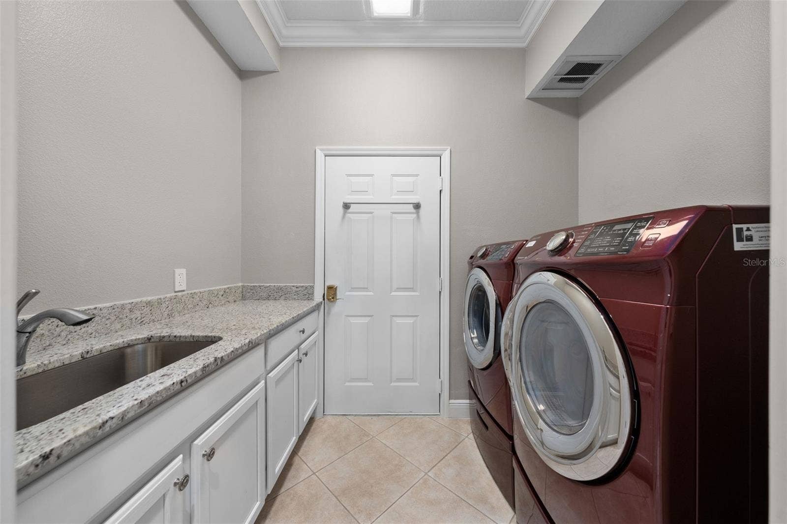 8432 MIRAMAR WAY, Lakewood Ranch, FL 34202 A spacious laundry room with front-load appliances, a utility sink, and plenty of counter and cabinet space.