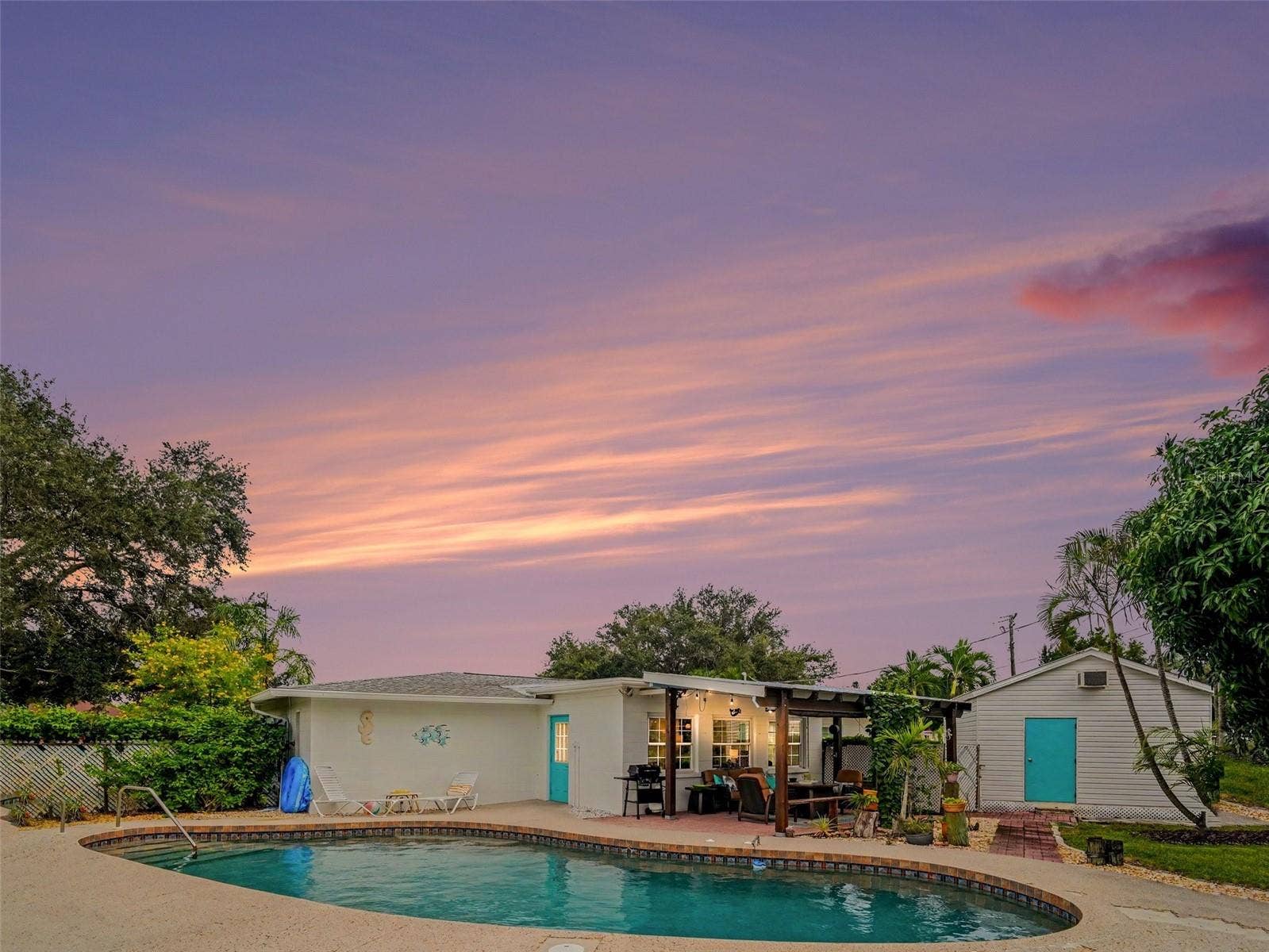 40 FT FREEFORM POOL, COVERED PATIO, WORKSHOP, ADDITIONAL SHED NOT PICTURED.  STUNNING SUNSETS FROM THE PATIO OR WALK DOWN THE STREET TO THE WATER