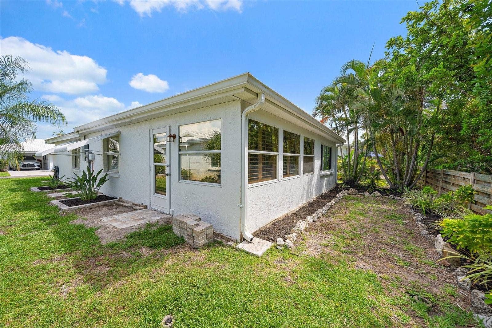 Exterior side view with carport and landscaping