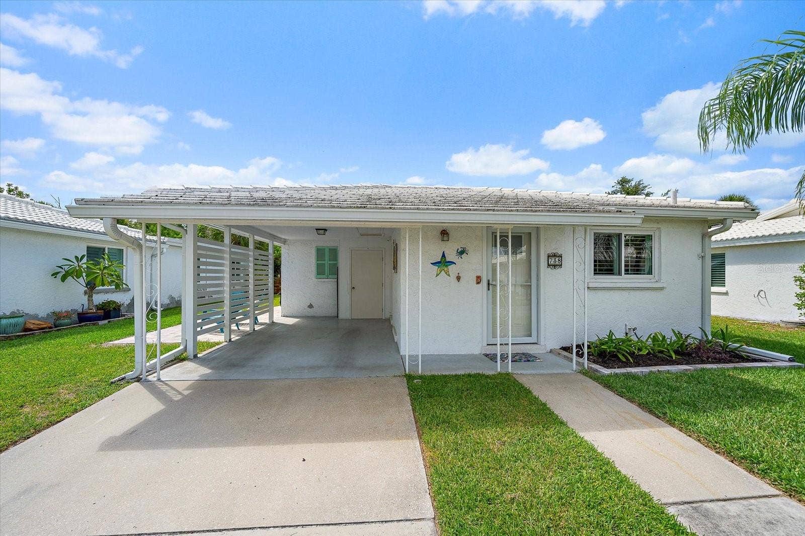 Front Covered entry and carport with landscaped walkway