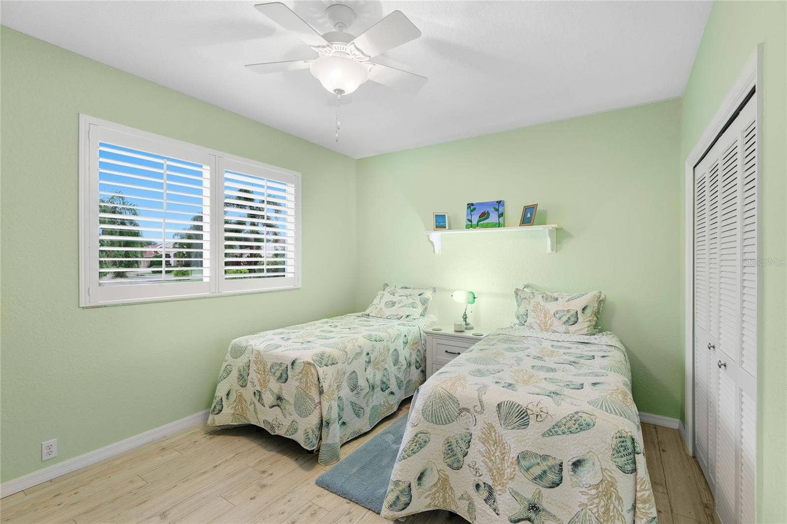 3306 LITTLE COUNTRY ROAD, Parrish, FL 34219 Guest bedroom two features custom louvered shutters, ceiling fan, and baseboard trim.