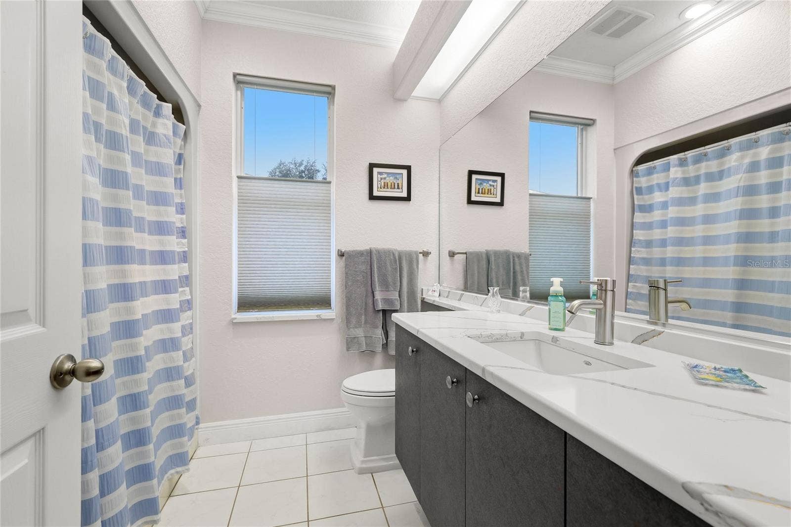 3306 LITTLE COUNTRY ROAD, Parrish, FL 34219 Guest bathroom features tile flooring, solid surface countertop, crown molding, updated plumbing fixtures, and Toto toilet.
