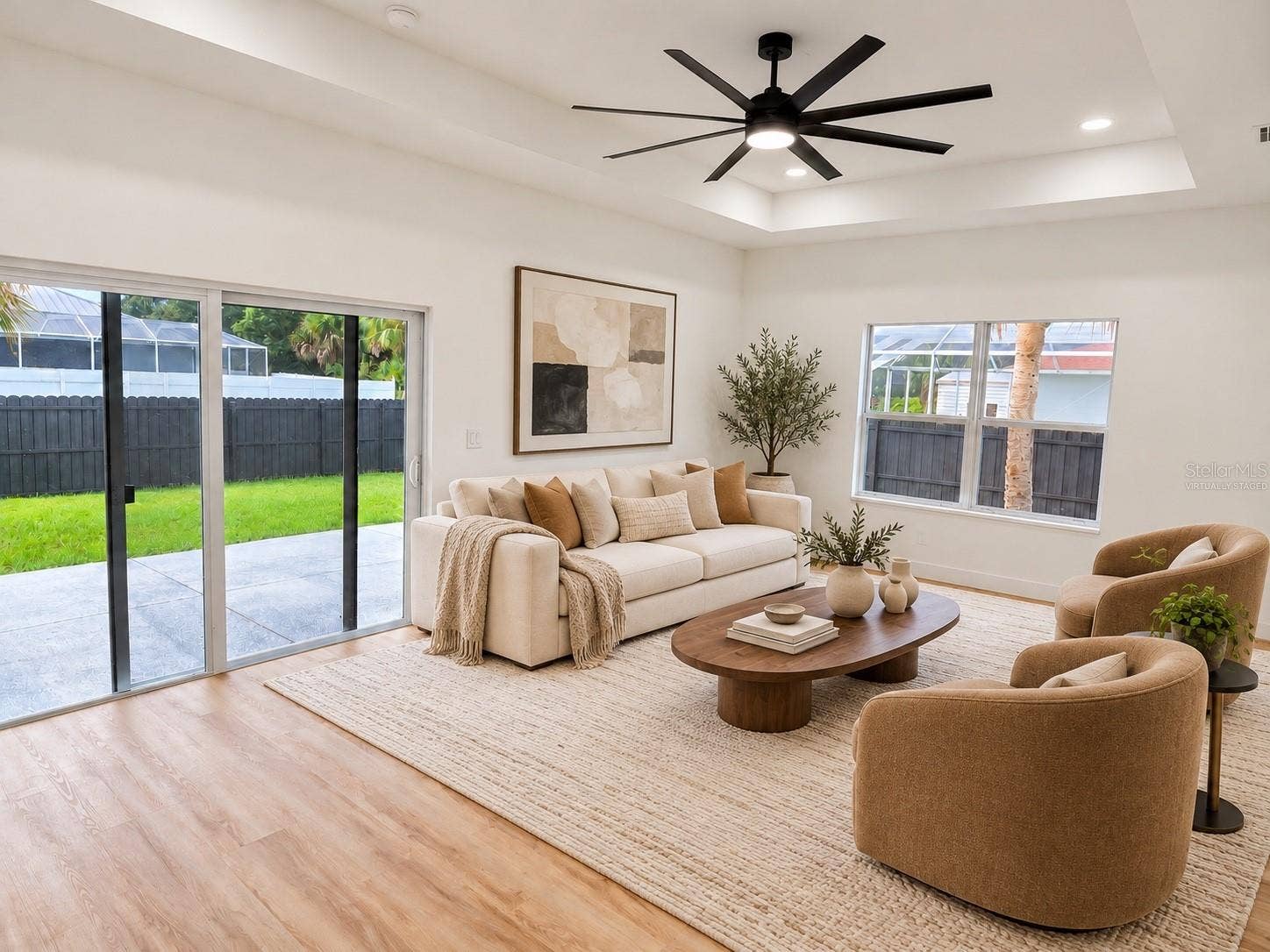 3126 BELLEVILLE TER, North Port, FL 34286 Virtually staged living room with sliding glass doors leading to the backyard.