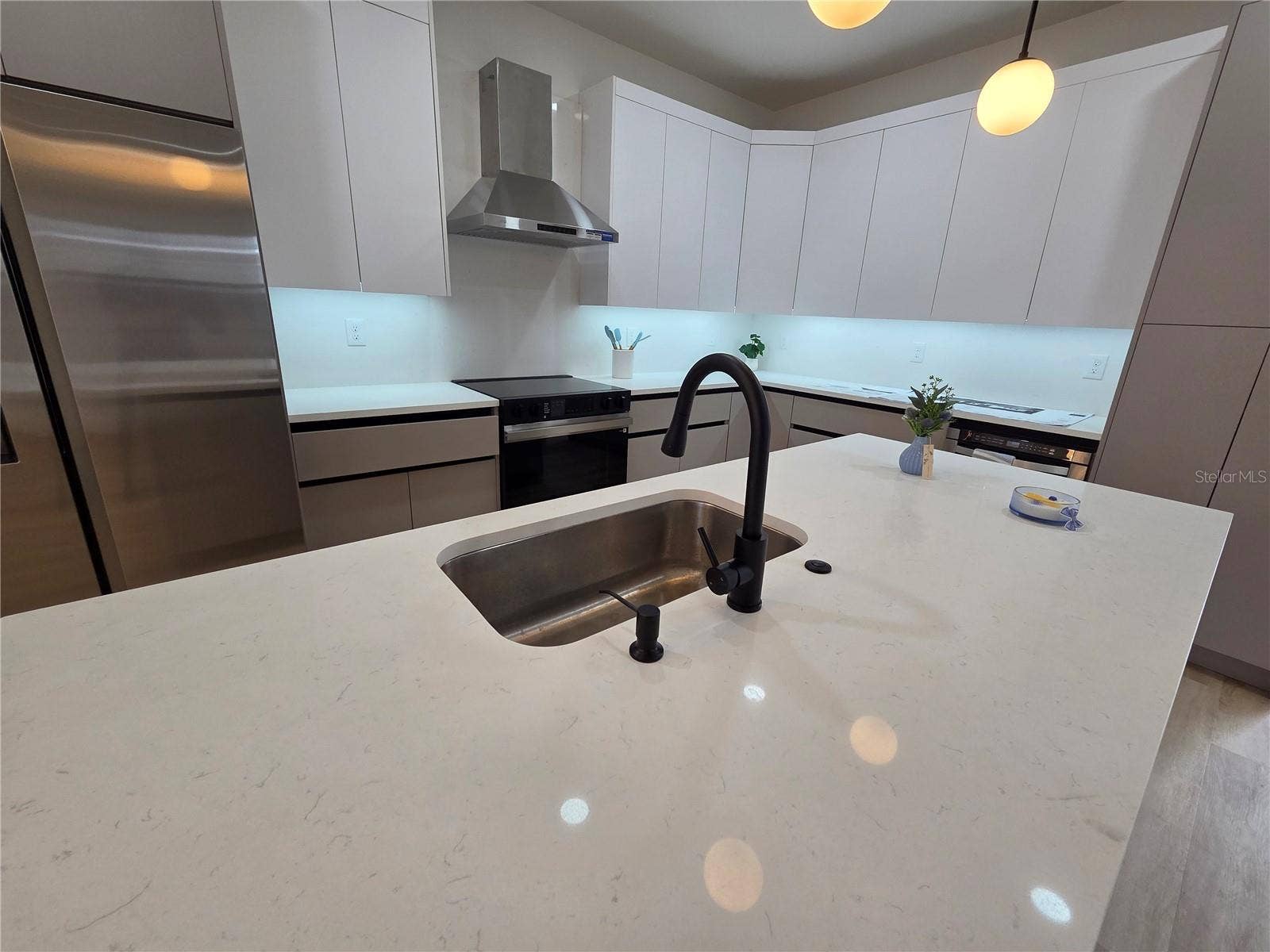 3126 BELLEVILLE TER, North Port, FL 34286 Kitchen island detail featuring a sink and modern faucet.