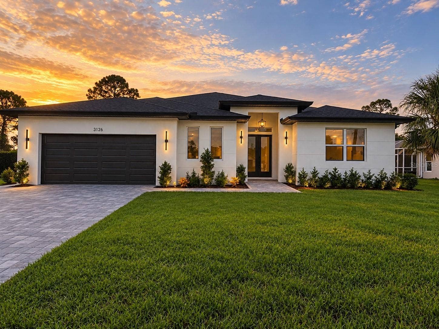 3126 BELLEVILLE TER, North Port, FL 34286 Front exterior at sunset showcasing the home's contemporary design.