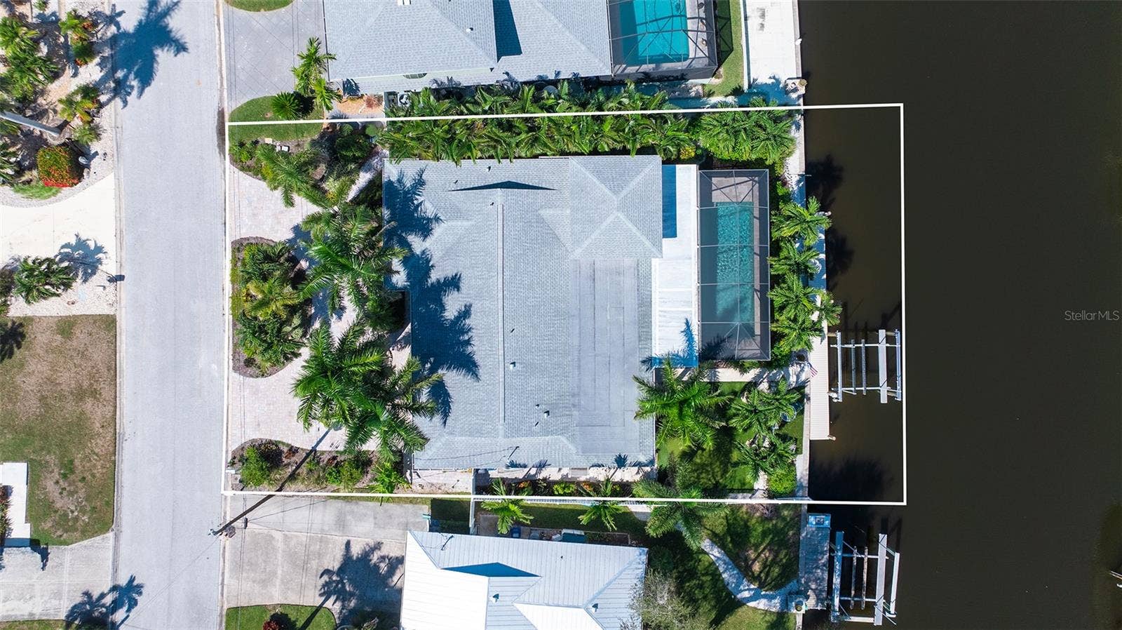 4907 CORAL BOULEVARD, Bradenton, FL 34210 An overhead view shows the home, pool enclosure, and waterfront layout.