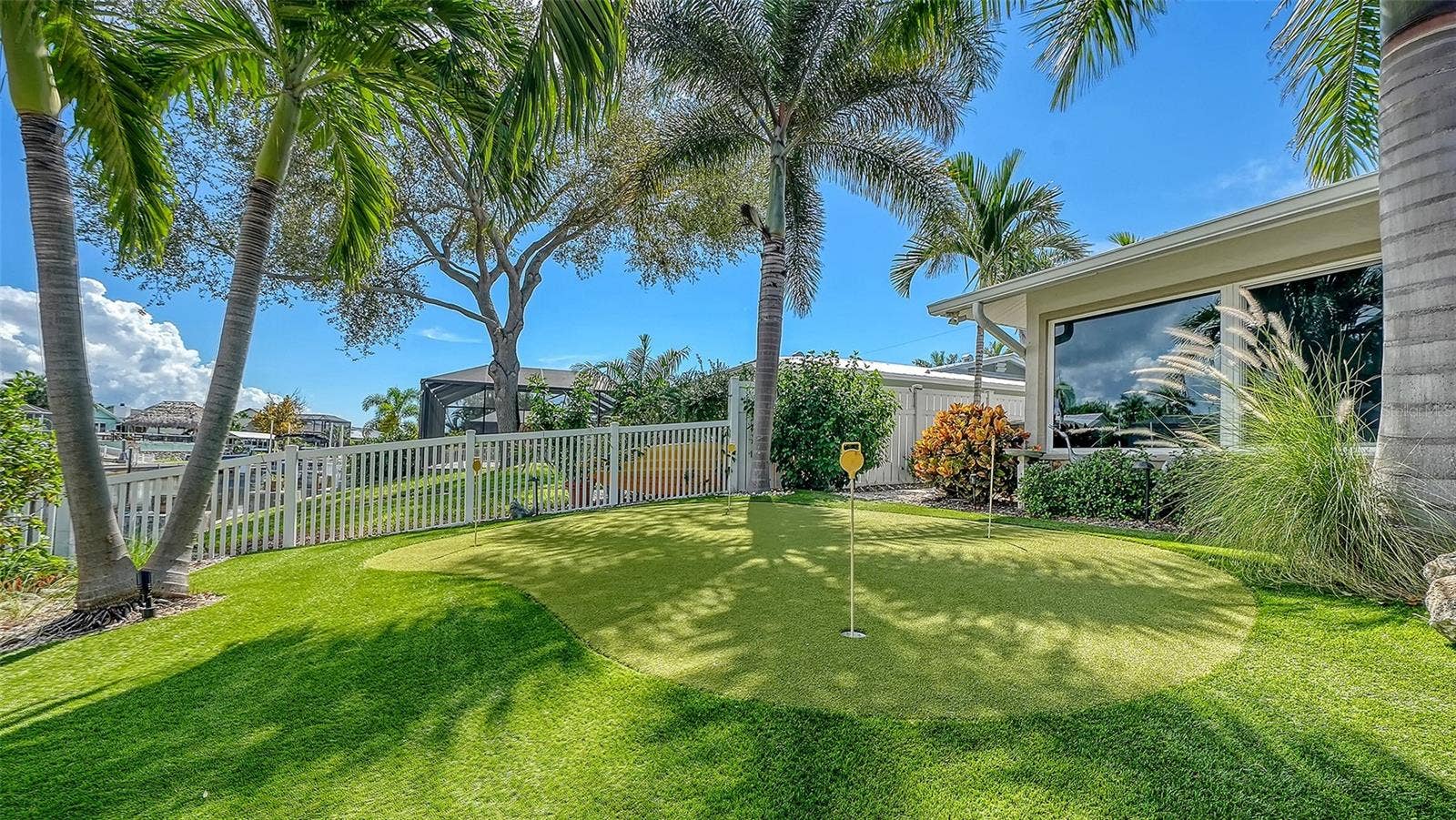 4907 CORAL BOULEVARD, Bradenton, FL 34210 A palm-lined putting green beside the waterfront setting.