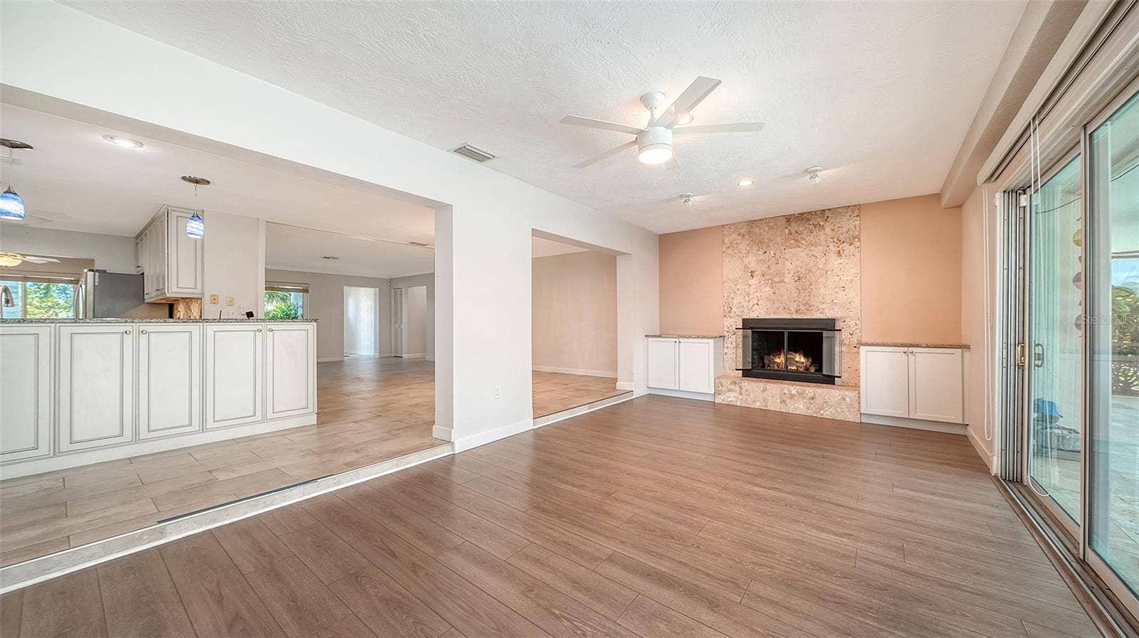 4907 CORAL BOULEVARD, Bradenton, FL 34210 A fireplace adds warmth to the connected living space.