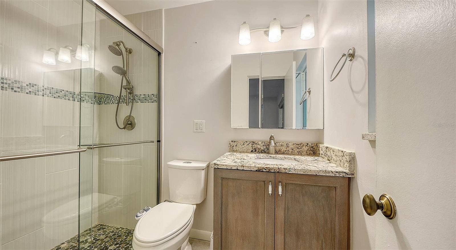 4907 CORAL BOULEVARD, Bradenton, FL 34210 A bathroom with a glass-enclosed shower and generous vanity.