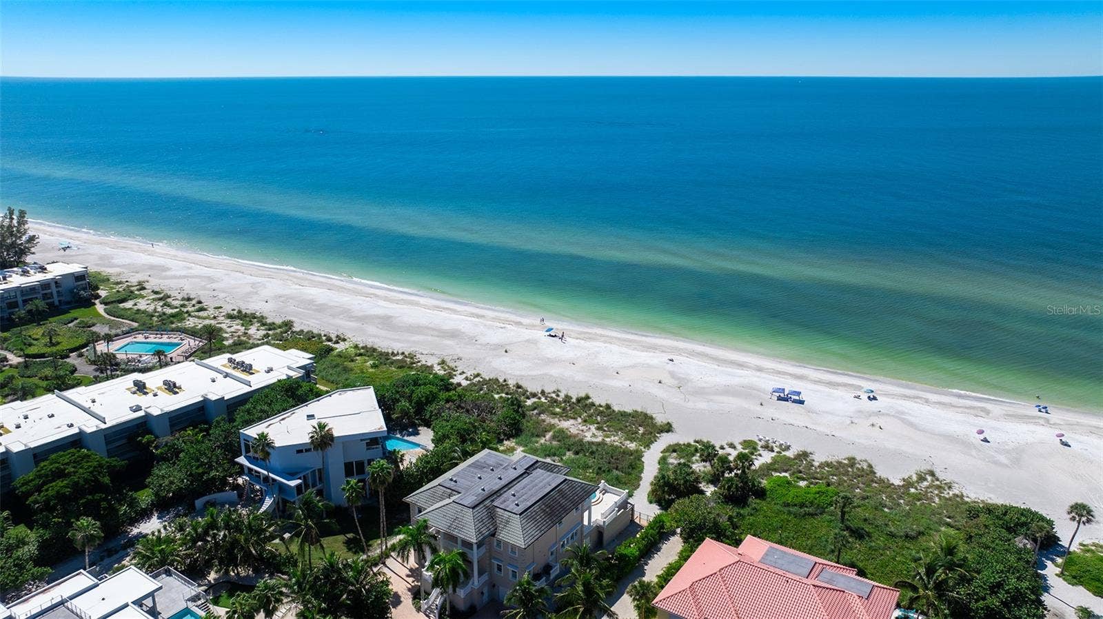 Spanish Main beach access - deeded path between red roof on the right and grey roof on the left.