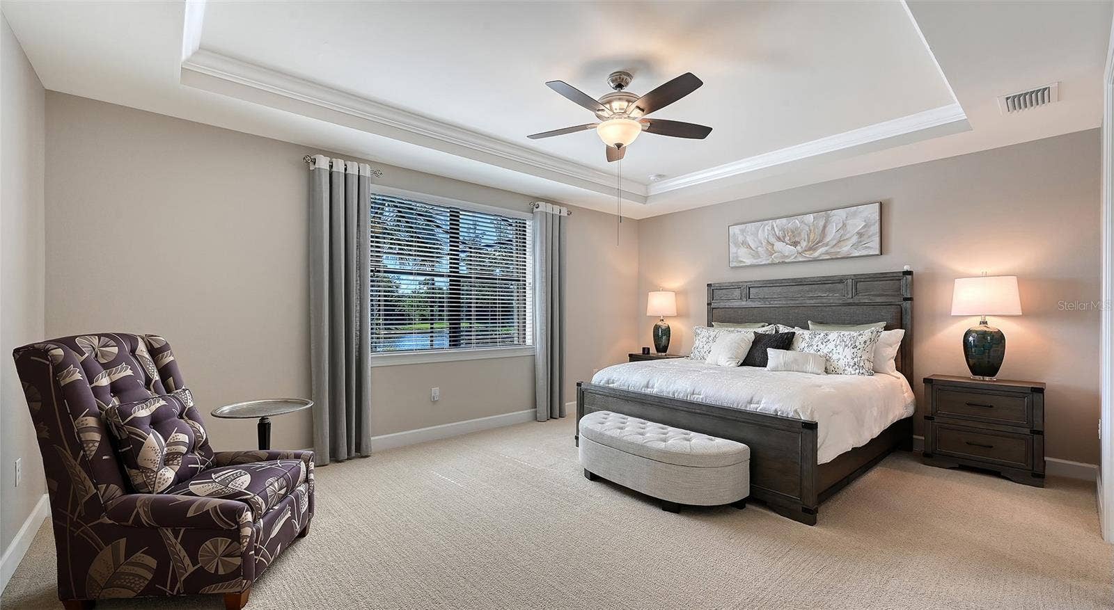 6827 GOSPORT COVE, Bradenton, FL 34202 This spacious primary suite features an elegant tray ceiling and captivating views of the sparking pool and picturesque water beyond.