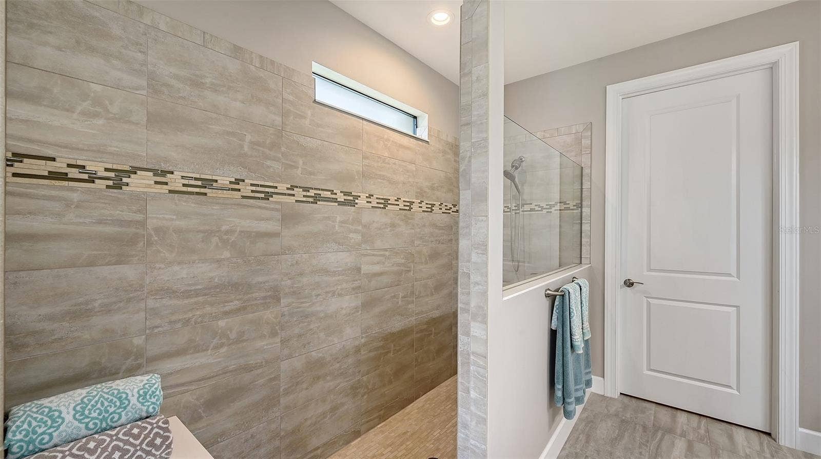 6827 GOSPORT COVE, Bradenton, FL 34202 The primary bath offers a spa-inspired retreat, featuring an oversized walk-in shower designed for relaxation and rejuvenation.