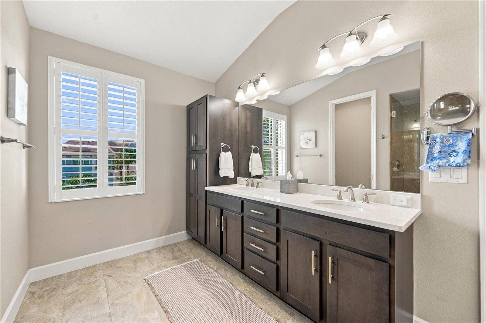 291 COMPASS POINT DRIVE, #201, Bradenton, FL 34209 The spacious primary ensuite features dual vanities, a large walk-in shower, a private water closet, and convenient access to one of the suites two walk-in closets.