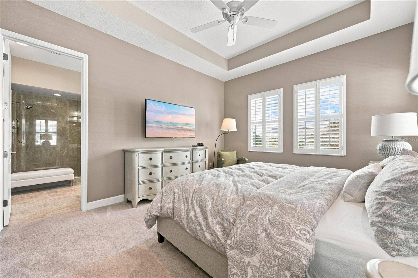 291 COMPASS POINT DRIVE, #201, Bradenton, FL 34209 spacious primary suite, featuring an elegant tray ceiling and two walk-in closets for ample storage.