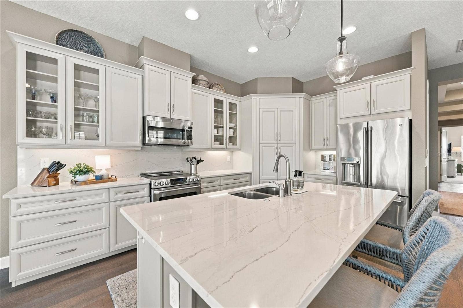 291 COMPASS POINT DRIVE, #201, Bradenton, FL 34209 The well-designed kitchen shines with GE Caf stainless steel appliances, elegant quartz countertops, and a spacious walk-in pantry.