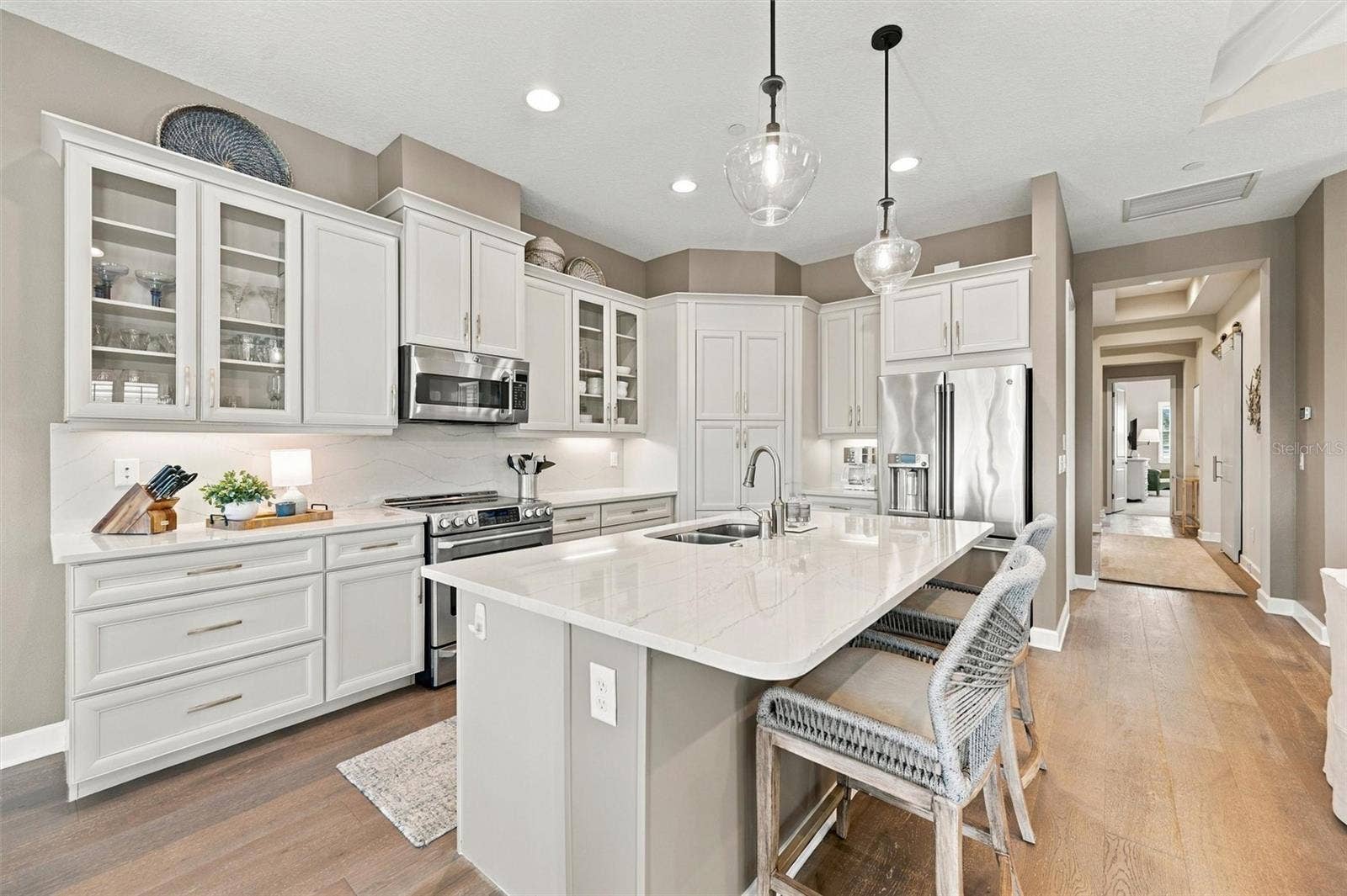291 COMPASS POINT DRIVE, #201, Bradenton, FL 34209 The well-designed kitchen shines with GE Caf stainless steel appliances, elegant quartz countertops, and a spacious walk-in pantry.