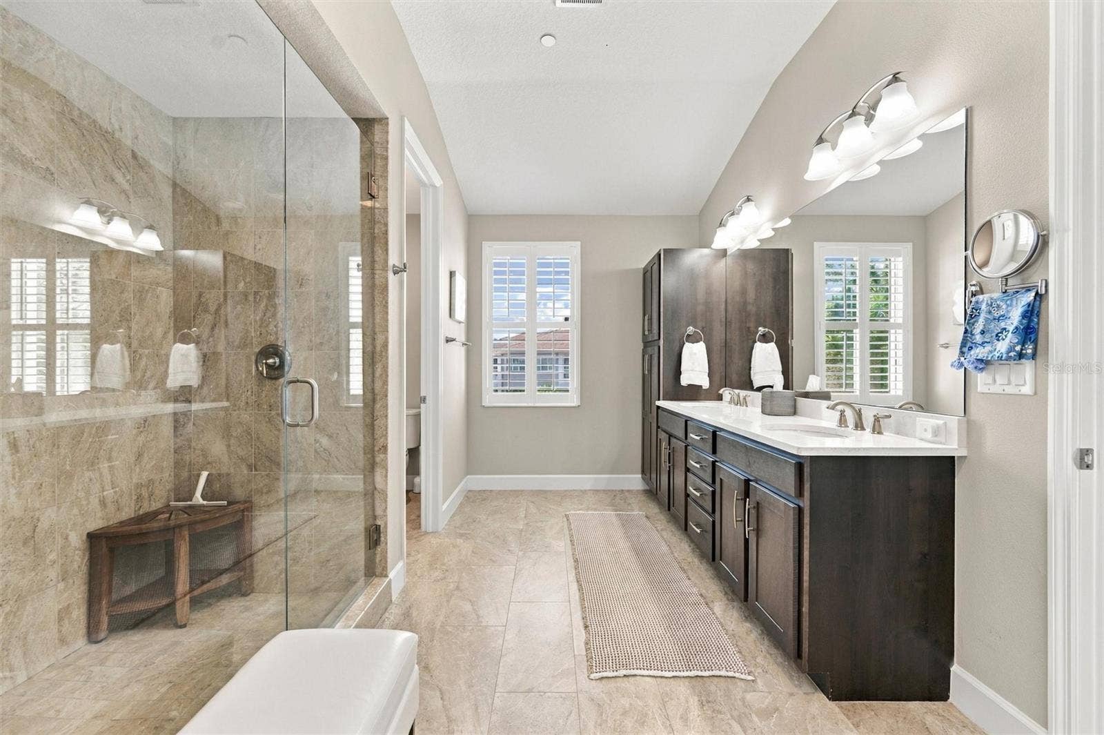 291 COMPASS POINT DRIVE, #201, Bradenton, FL 34209 The spacious primary ensuite features dual vanities, a large walk-in shower, a private water closet, and convenient access to one of the suites two walk-in closets.