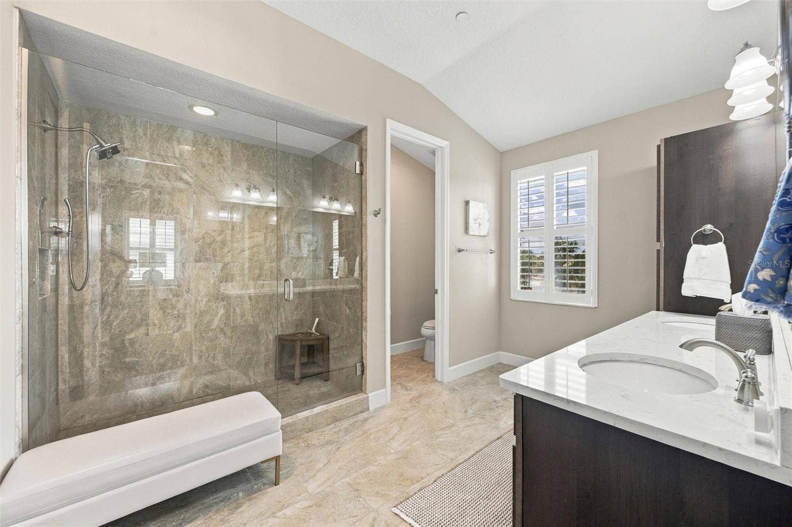 291 COMPASS POINT DRIVE, #201, Bradenton, FL 34209 The spacious primary ensuite features dual vanities, a large walk-in shower, a private water closet, and convenient access to one of the suites two walk-in closets.