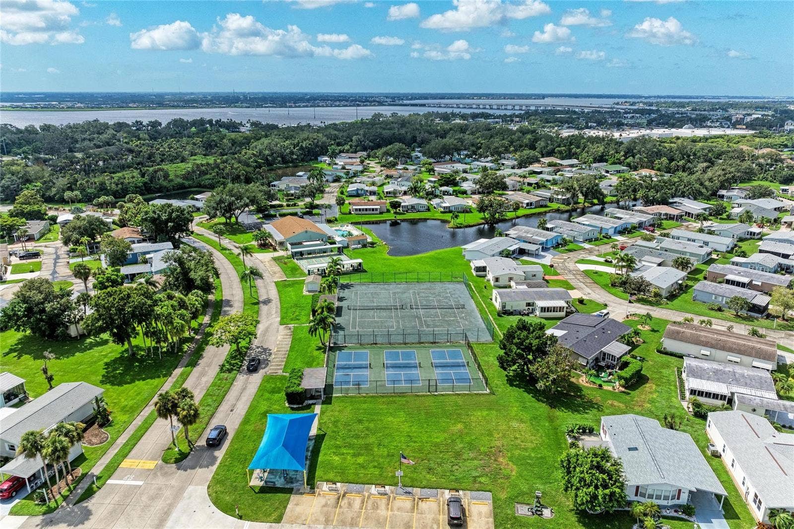 42 MEADOWLARK CIRCLE, Ellenton, FL 34222 View of tennis and pickelball courts. Under the blue cover is the small fitness "gym"
