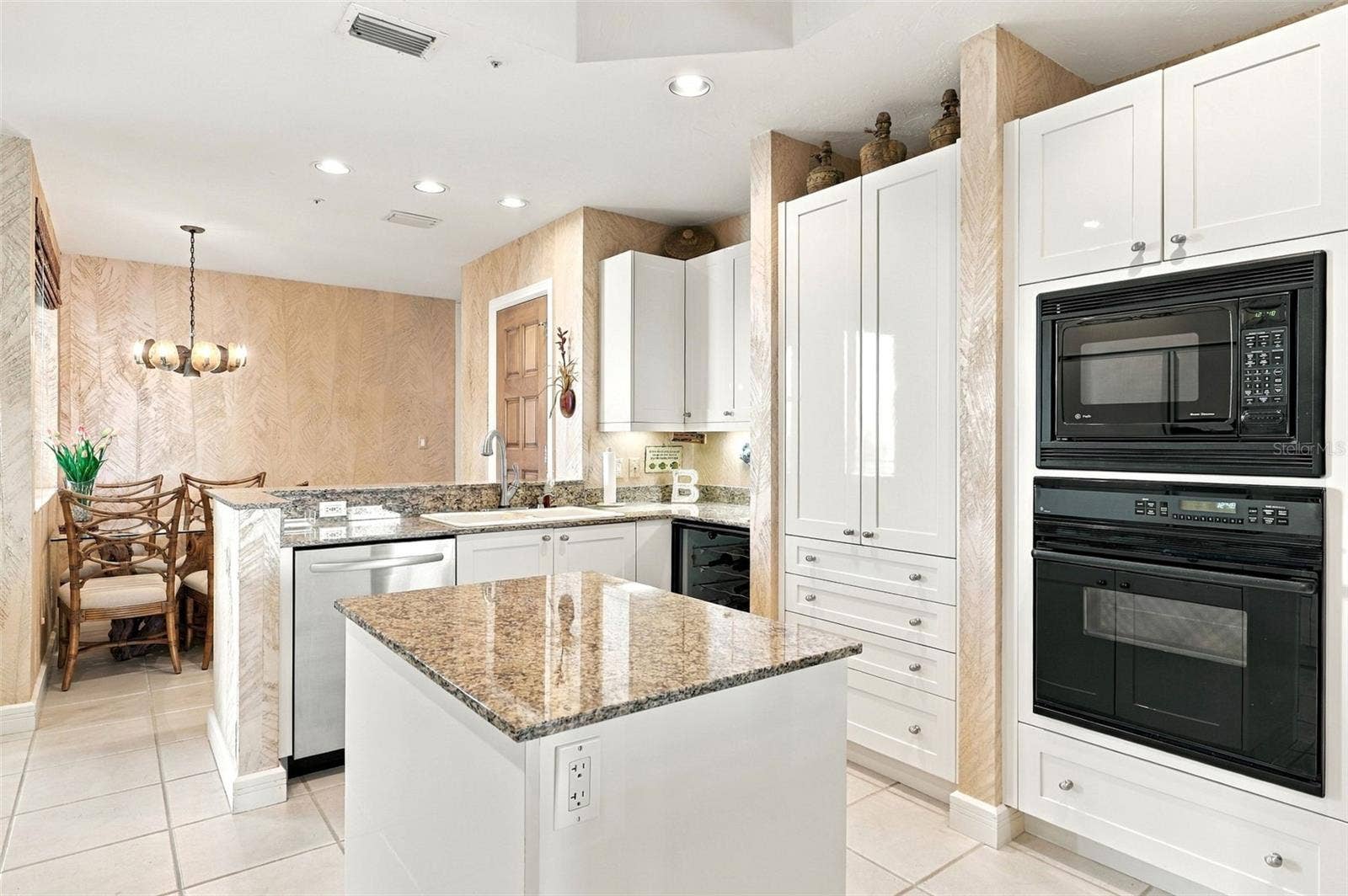 2185 GULF OF MEXICO DRIVE, #243, Longboat Key, FL 34228 Thoughtfully designed kitchen with shaker style cabinetry, center island with cabinets and pull out drawers, planning desk, and wine refrigerator and closet pantry.