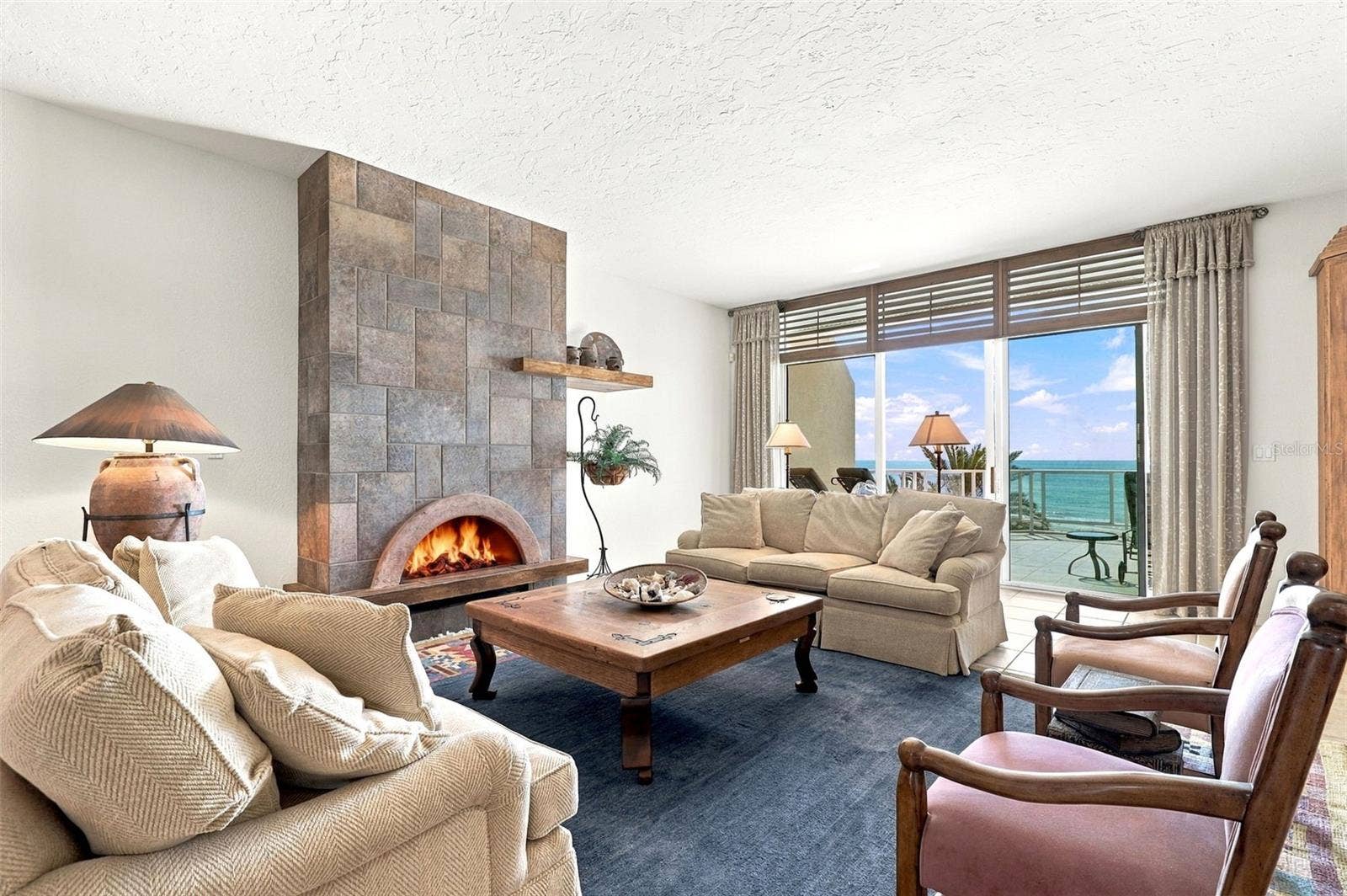 2185 GULF OF MEXICO DRIVE, #243, Longboat Key, FL 34228 The living room has built-in cabinetry, a gas fireplace, and glass sliders onto a large balcony.