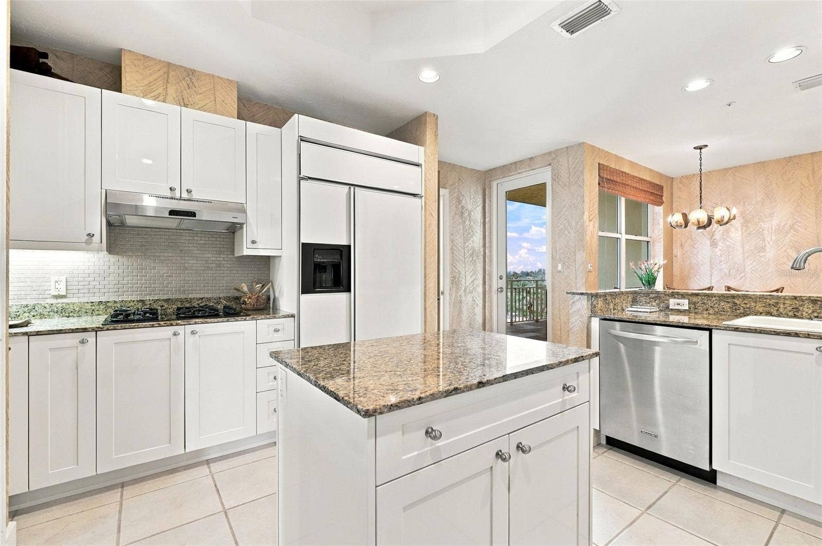 2185 GULF OF MEXICO DRIVE, #243, Longboat Key, FL 34228 Cooktop with natural gas, under cabinet lighting and mini subway tile backsplash.