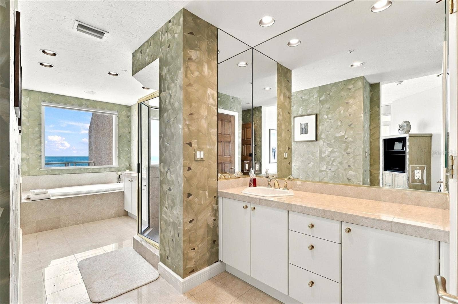 2185 GULF OF MEXICO DRIVE, #243, Longboat Key, FL 34228 The primary ensuite bathroom offers dual vanities, marble floors and a huge spa tub overlooking the water and beach view.