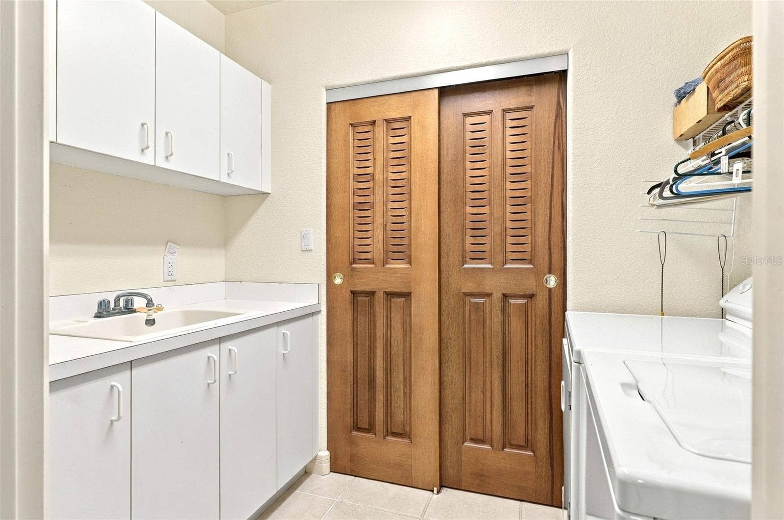 2185 GULF OF MEXICO DRIVE, #243, Longboat Key, FL 34228 In unit laundry with fitted cabinetry, laundry tub, and utility closet.