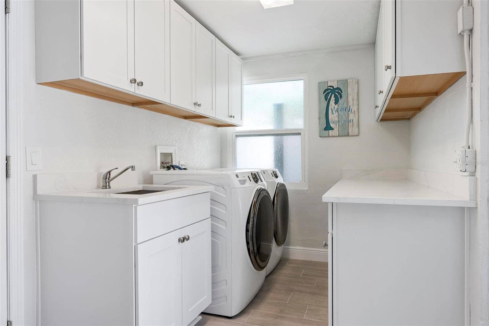 504 69TH STREET, Holmes Beach, FL 34217 Indoor laundry room with utility sink and storage