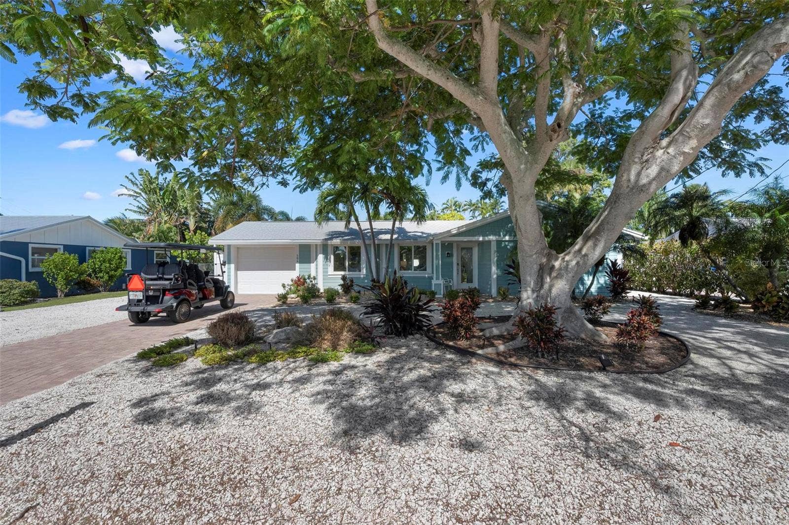 504 69TH STREET, Holmes Beach, FL 34217 Front of home with beautiful poinciana tree