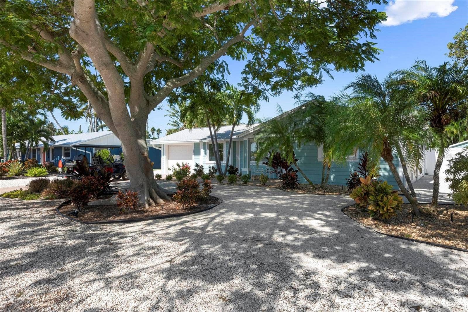 504 69TH STREET, Holmes Beach, FL 34217 Front of home with beautiful poinciana tree
