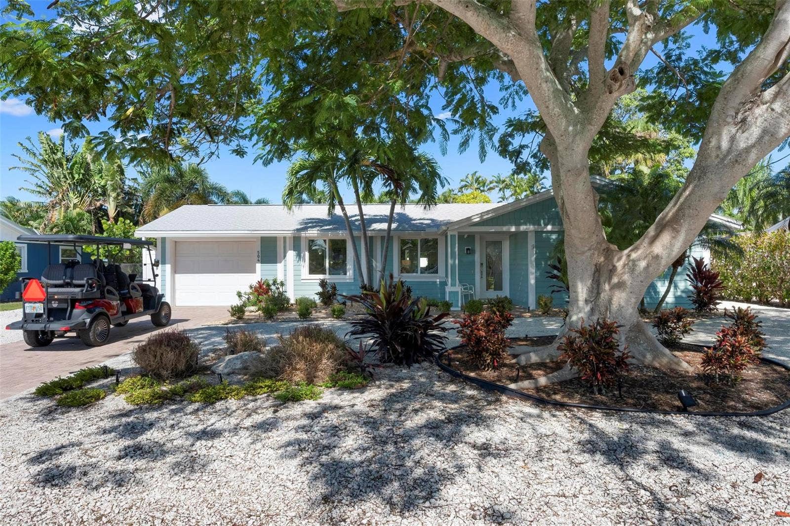 504 69TH STREET, Holmes Beach, FL 34217 Front of home with beautiful poinciana tree