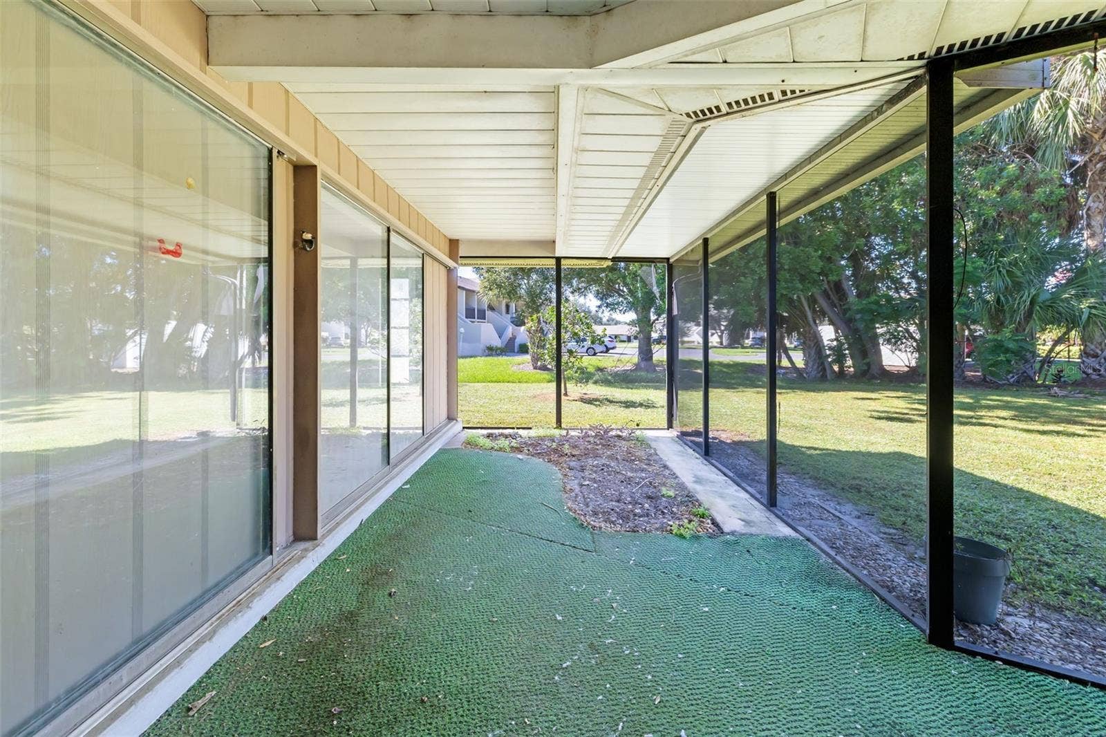 Expansive screened lanai with ceiling fan and pond view, made for relaxing and entertaining.