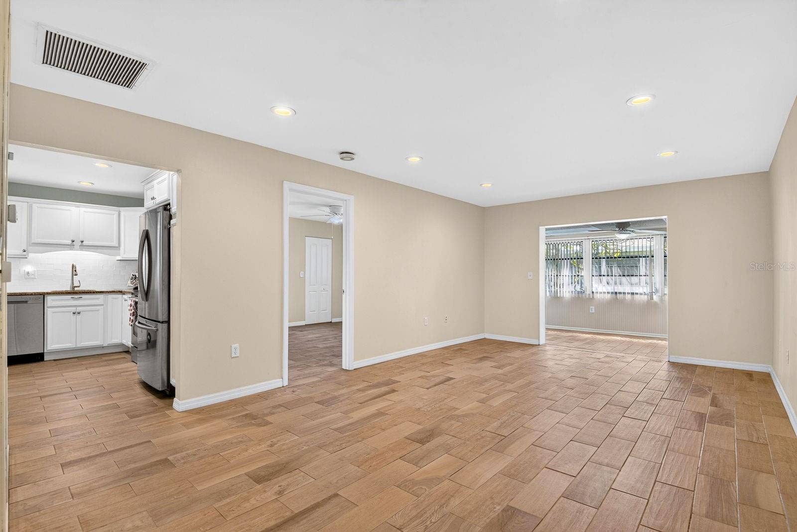 390 301 BOULEVARD W, #10C, Bradenton, FL 34205 Living Room to Dining Area and Kitchen and Primary Bedroom