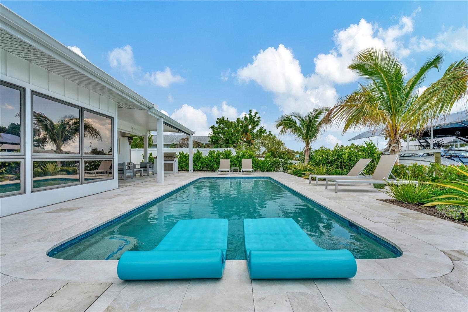 10115 KINGFISHER ROAD E, Bradenton, FL 34209 Heated saltwater pool, covered lanai, outdoor terraces, built-in propane grill, and tiki hut with turf games area.