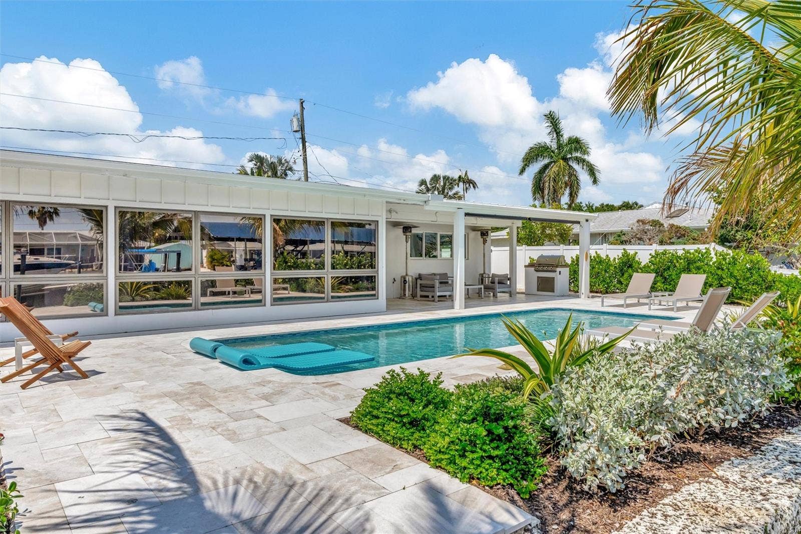 10115 KINGFISHER ROAD E, Bradenton, FL 34209 Heated saltwater pool, covered lanai, outdoor terraces, built-in propane grill, and tiki hut with turf games area.