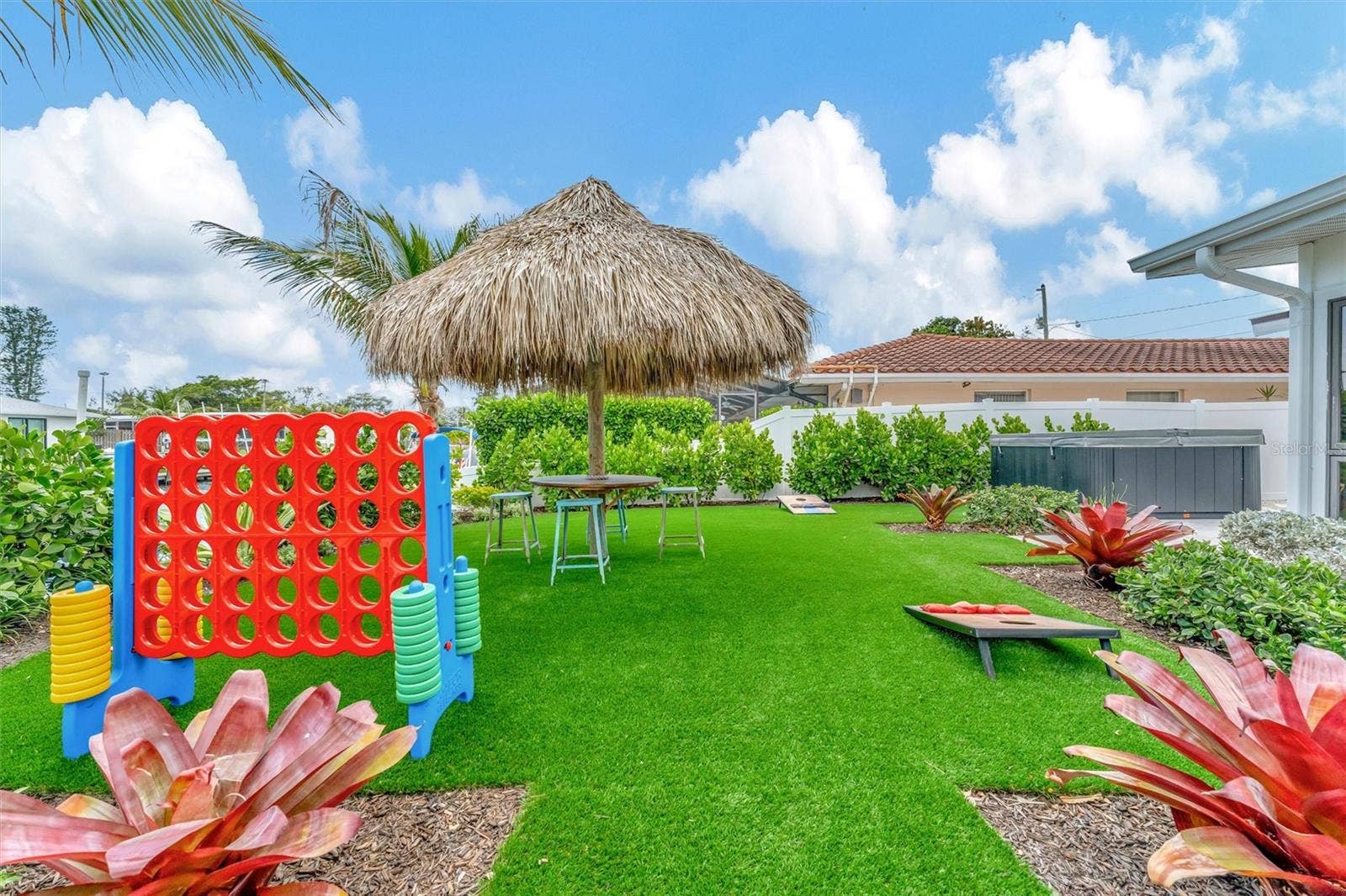 10115 KINGFISHER ROAD E, Bradenton, FL 34209 Covered lanai, multiple terraces, built-in propane grill, and tiki hut with turf games area.